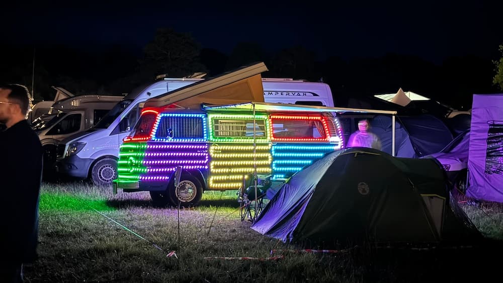 A photo of a camper van covered in colourful, bright lights